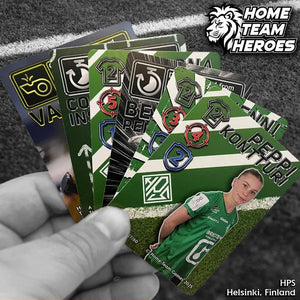 Hand holding HPS Helsinki Team Deck cards with Peppi Kontturi and teammates in green kits on pitch background.