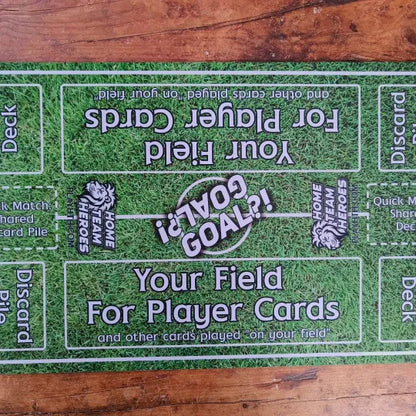 Top view of Home Team Heroes football playmat with grass pitch design, player zones, and a goal marker for tabletop play.