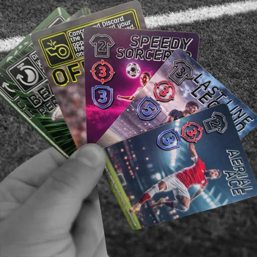 Hand holding fan of football trading cards featuring player cards including Speedy Sorcerer, Lastline Legend, and Aerial Ace with skill ratings, displayed over soccer field turf with white line marking